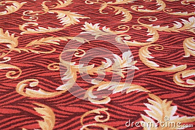 Leafs vines floral patterns prints on a red light orange beige colored floor carpet cloth Stock Photo