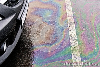 Leakage of oil or gasoline from the car on the asphalt in the parking lot. Stock Photo
