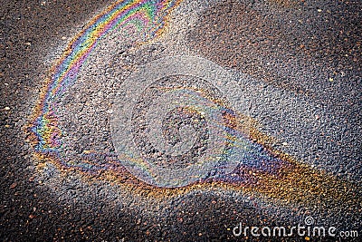 Leakage of oil or gasoline from a car on wet asphalt on a bright sunny day Stock Photo
