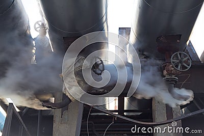 Leakage of steam in heat pipeline. Steam outgoing from the rusty tube with valve Stock Photo