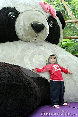 Leaning against giant panda doll Stock Photo