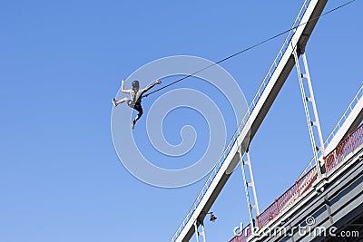 Leap from the bridge with the rope. Extreme sport, jumping, adrenaline. The man jumped from the bridge with the rope Editorial Stock Photo