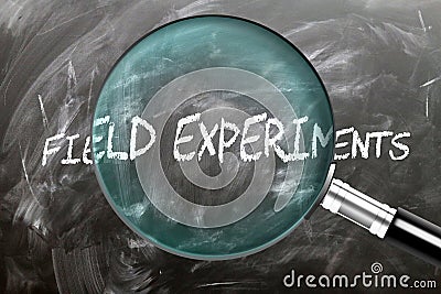 Learn, study and inspect Field Experiments. A magnifying glass enlarging word 'field experiments' written on a Stock Photo