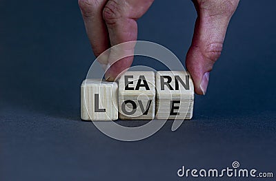 Learn to love symbol. Businessman turns wooden cubes and changes the word `love` to `learn`. Beautiful grey background. Learn Stock Photo