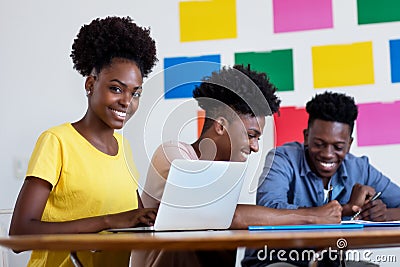 Learning african american female student at computer with group of students Stock Photo