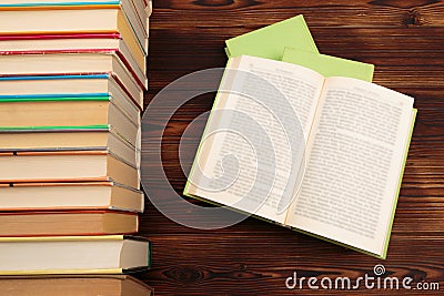 Learning concept with opening book or textbook in old library, stack piles of literature text academic archive on reading desk Stock Photo