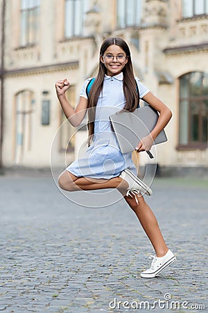 Learning needs change fast. Happy child hurry to school. Little girl carry laptop computer. Modern e-learning. Virtual Stock Photo