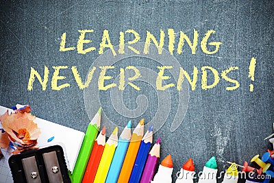 Learning never ends text on blackboard with office tools Stock Photo