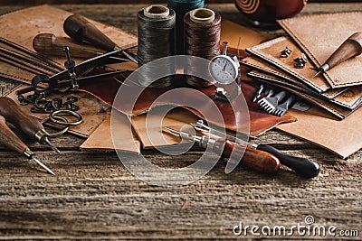 Leather craft tools on old wood table. Leather craft workshop. Stock Photo