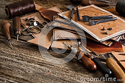 Leather craft tools on old wood table. Leather craft workshop Stock Photo