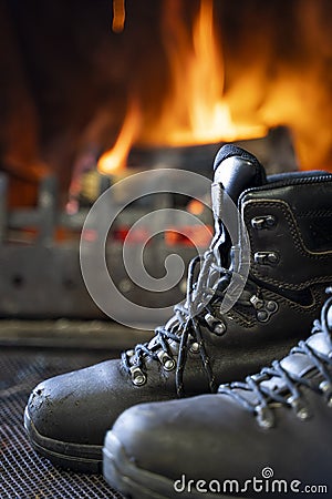 Leather hiking boots drying by the fireplace Stock Photo