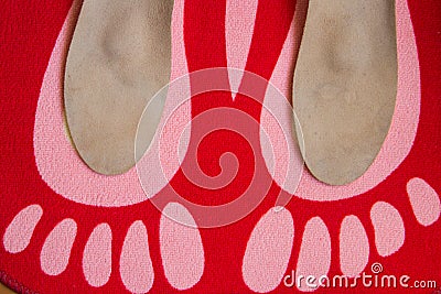 Leather orthopedic insoles are located on a red home carpet with Stock Photo