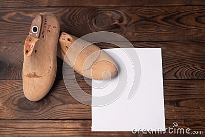 Leather samples for shoes and wooden shoe last on dark wooden table Stock Photo