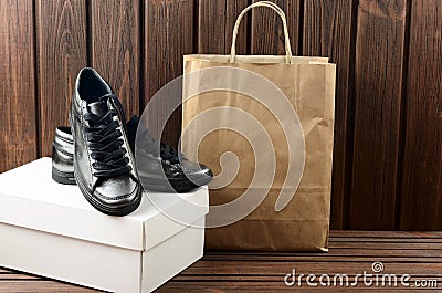 Leather upper metallic trandy womens shoes on brown wooden background. Shopping purchases Stock Photo