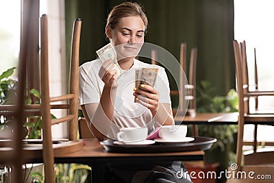 Leave tipping for the waiter in cafe. salary or tips, counting money with satisfaction on face. waitress while count Stock Photo