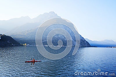 Lecco, Italy - November 8, 2020: Kayaking, canoeing, paddling on mountain lake Como during sunrise or sunset. Man Editorial Stock Photo