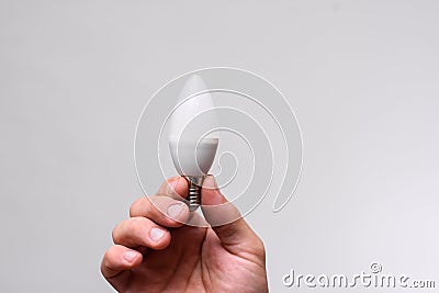 LED lamp in the shape of a candle in the hand Stock Photo