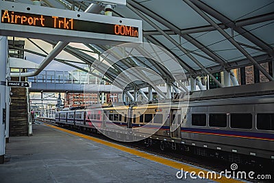 An LED sign displaying, Airport trk1 00min, and the A line light rail train departing Denver Union Station on a cold winter day Stock Photo
