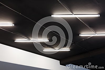 Led tube lights on black office ceiling. Minimal loft design Stock Photo