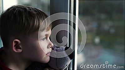 Ledset Little Boy ensamt barn med björnen nära att se till och med fönster Little Boy stock video Ledset Little Boy ensamt barn med björnen nära att se till och med fönster Little Boy stock video