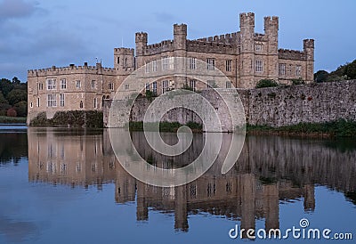 Leeds Castle in Kent UK, reflected in the surrounding moat, photographed in late afternoon on a clear crisp autumn afternoon. Stock Photo