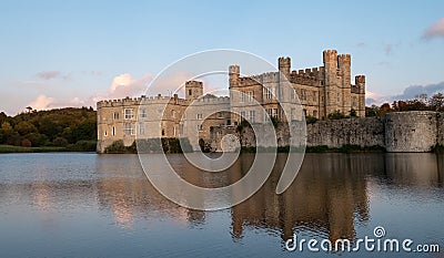 Leeds Castle in Kent UK, reflected in the surrounding moat, photographed in late afternoon on a clear crisp autumn day. Stock Photo