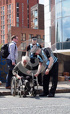 Police liaison officers helping a man in a wheelchair at the extinction rebellion protest blocking the road at victoria bridge in Editorial Stock Photo