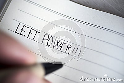 Left-handed man handwriting the text left power Stock Photo