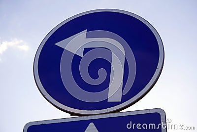 Left turn road sign over blue sky Stock Photo