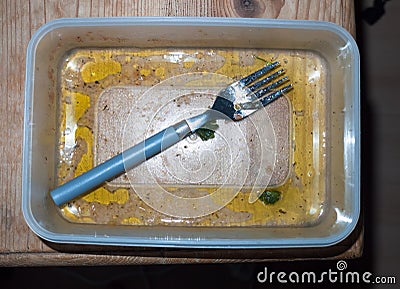 Leftovers eaten and dirty tupperware and fork empty unclean Stock Photo