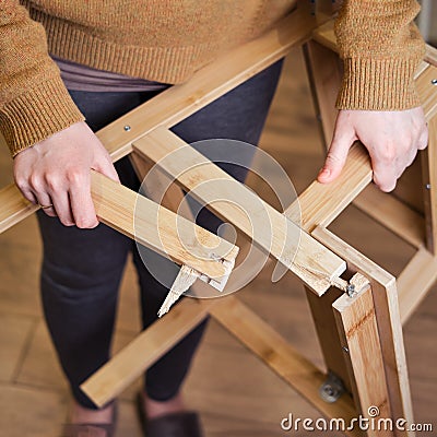 The leg of the wooden stepladder broke at the base. Ladder broke in the hands of a woman safety problems. Safety issues at work Stock Photo