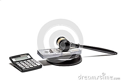 A legal gavel atop American currency with a calculator, depicting financial law or fines. Stock Photo