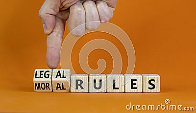 Legal or moral rules symbol. Businessman turns wooden cubes and changes words `legal rules` to `moral rules` on a beautiful or Stock Photo