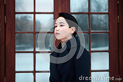 Legant millennial young woman wearing blue coat in cool winter day Stock Photo