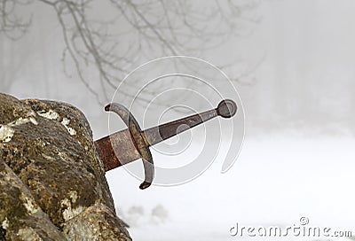 legendary Excalibur sword into the stone in the middle of the forest Stock Photo