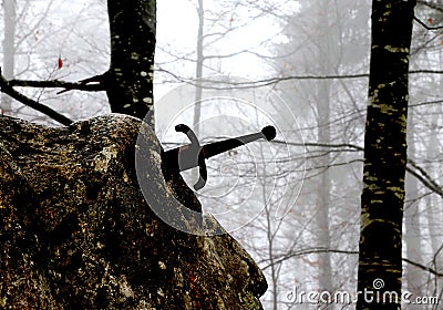 legendary Excalibur sword into the stone in the middle of the fo Stock Photo