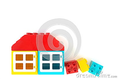 Lego background. House made of Small and big plastic constructor bricks on white background. Popular toys Stock Photo