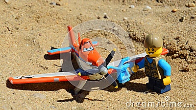 LEGO City figure of boy adding oil to propeller of die cast Mattel model of Dusty Crophopper airplane Editorial Stock Photo