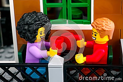 Lego couple minifigures with mugs sitting on the terrace Editorial Stock Photo