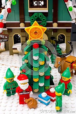 Lego Elves, Reindeer and Santa Claus with bag standing near Christmas tree opposite Elf Club House Editorial Stock Photo