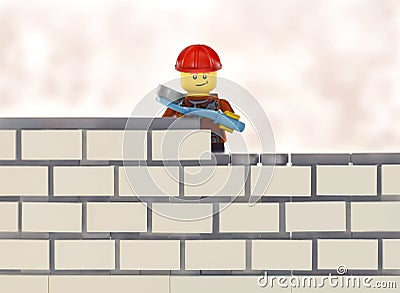 Lego minifigure worker by brick wall building Editorial Stock Photo