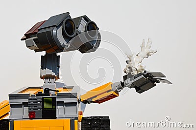 LEGO figure of Wall-E robot from Disney Pixar movie adoring white sea coral in his left arm, light grey background. Editorial Stock Photo
