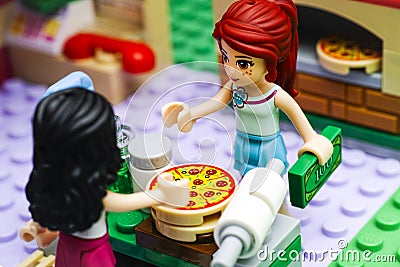 Lego girl with money buying pizza in Pizzeria Editorial Stock Photo