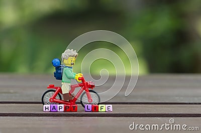 lego hiker riding bicycle with word happy life Editorial Stock Photo