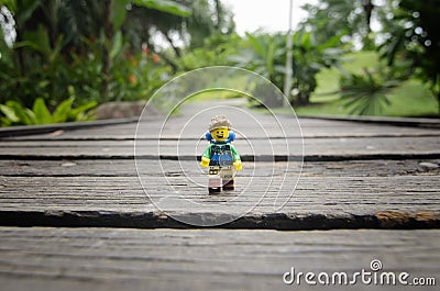 Lego hiker walking on wooden bridge at lake garden. Editorial Stock Photo