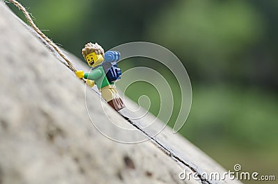 Lego minifigure hiker climbing rock mountain. Editorial Stock Photo