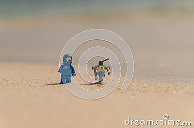 Lego movie minifigure spaceman Benny with robot on the baech Editorial Stock Photo