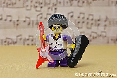 Lego Toy male figure smiling character with an afro, goatee Wearing funky glasses, with guitar Editorial Stock Photo