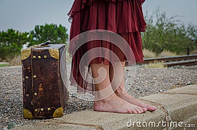 Legs with bare feet of woman with suitcase Stock Photo