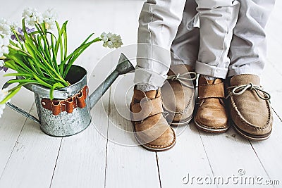 Legs of boy and man, in moccasins with flowers Stock Photo